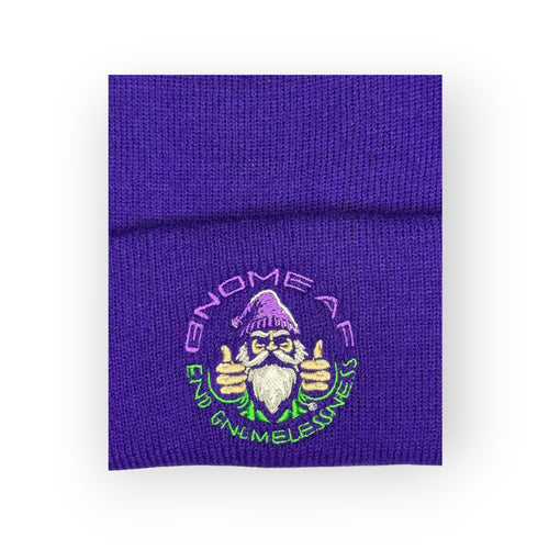 End Gnomelessness beanie laid flat, close-up of the embroidered gnome logo